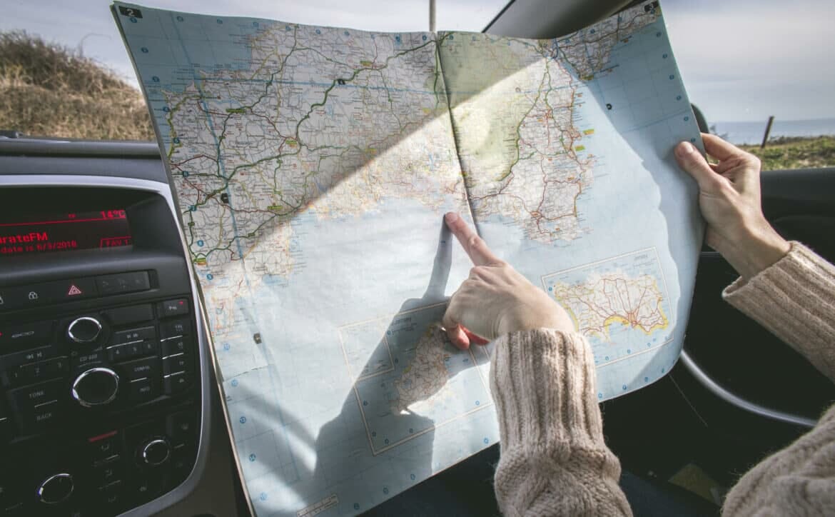 person wearing beige sweater holding map inside vehicle stockpack pexels scaled