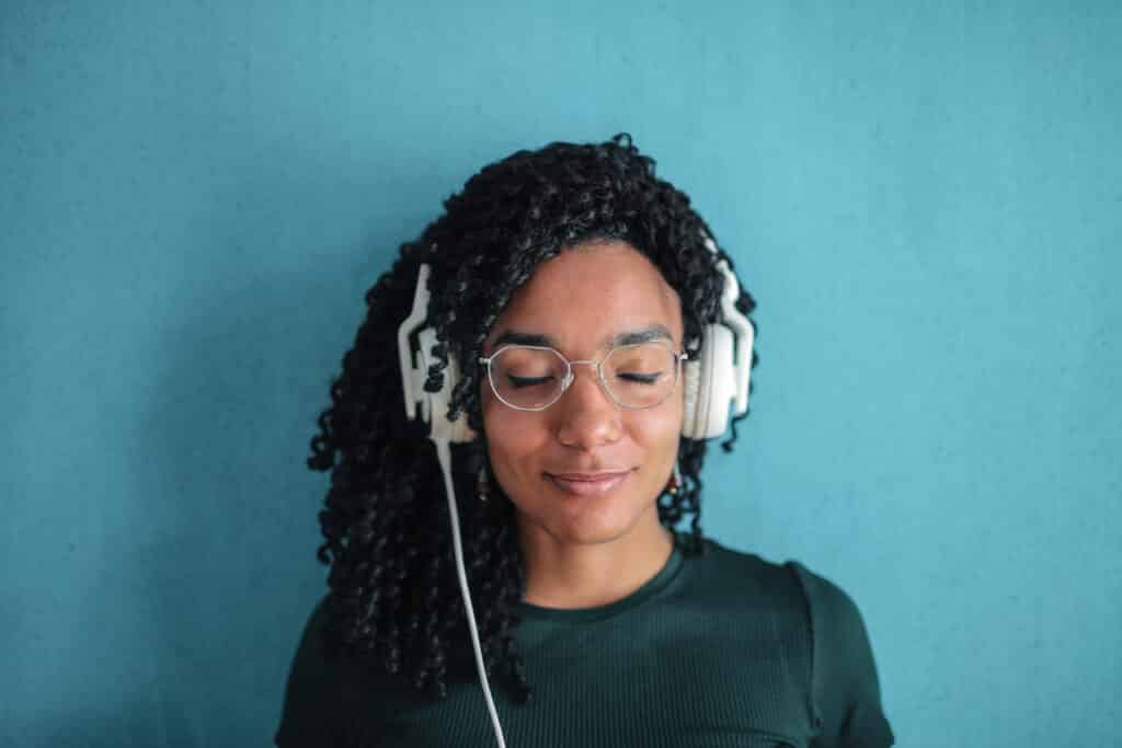 portrait photo of smiling woman in black top and glasses wearing white headphones stockpack pexels scaled