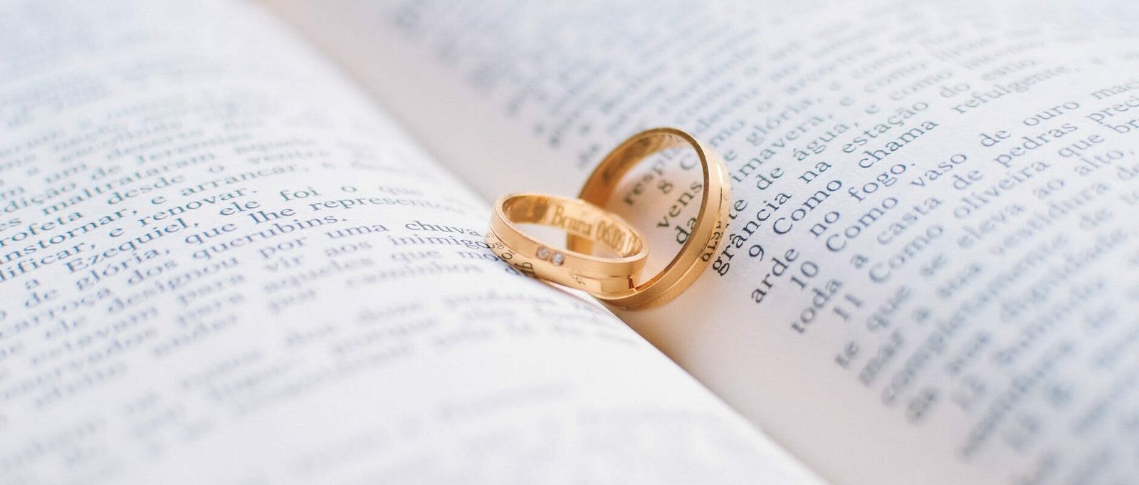 two gold colored wedding bands on book page